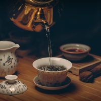 gold-kettle-pouring-hot-water-on-cup-of-tea-230477