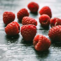 raspberries-on-black-wooden-board-1046350